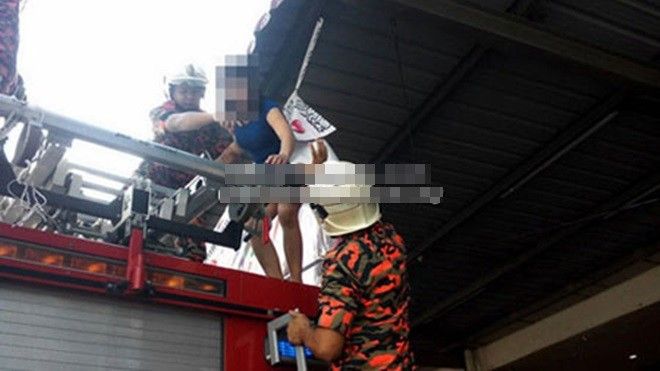 Lính cứu hỏa giải cứu Tran Thi Kim Yen. Ảnh: Borneo Post.